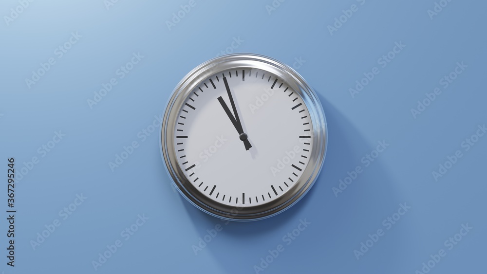 Glossy chrome clock on a blue wall at fifty-seven past ten. Time is 10:57 or 22:57 Glossy chrome clock on a blue wall at fifty-seven past ten. Time is 10:57 or 22:57