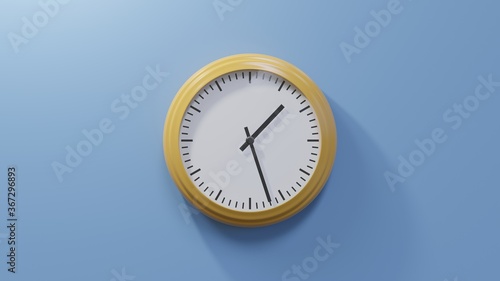 Glossy orange clock on a blue wall at twenty-seven past one. Time is 01:27 or 13:27