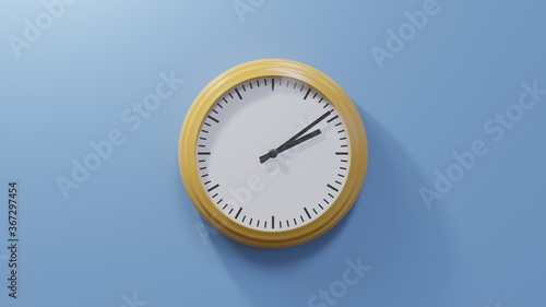 Glossy orange clock on a blue wall at nine past two. Time is 02:09 or 14:09