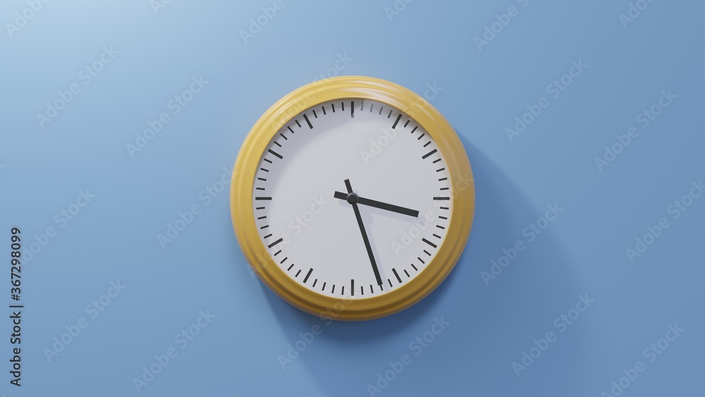Glossy orange clock on a blue wall at twenty-seven past three. Time is 03:27 or 15:27 Glossy orange clock on a blue wall at twenty-seven past three. Time is 03:27 or 15:27