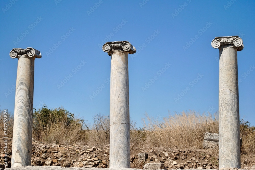 Three classical Ionic marble columns at ruin ancient city of Perge, near Antaliya, Turkey.