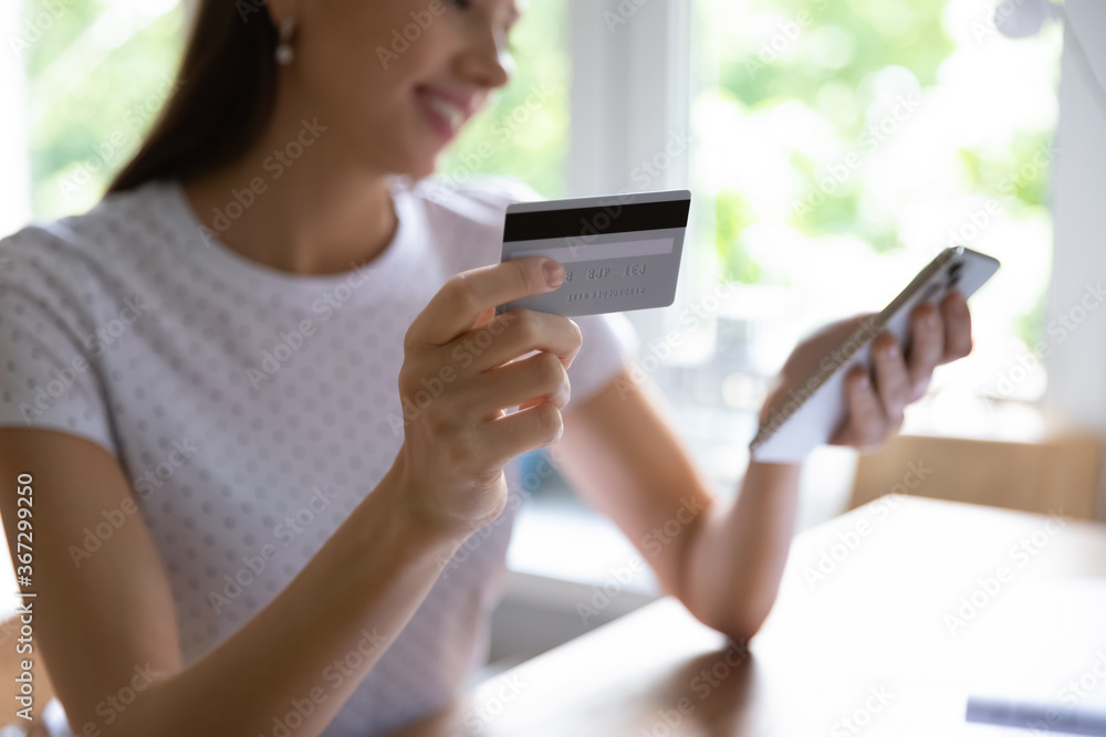 Close up of young woman make online payment or purchase using plastic credit card and smartphone gadget, millennial Caucasian girl shopping on internet use cellphone web banking service system Close up of young woman make online payment or purchase using plastic credit card and smartphone gadget, millennial Caucasian girl shopping on internet use cellphone web banking service system