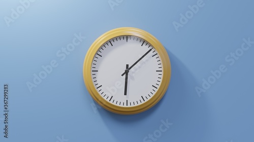 Glossy orange clock on a blue wall at eight past six. Time is 06:08 or 18:08