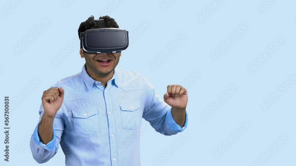 Portrait of young scared man using virtual reality glasses. Future technology and innovation concept. Portrait of young scared man using virtual reality glasses. Future technology and innovation concept.