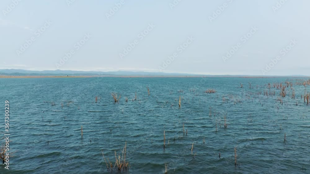 Lake Nakai and its dead trees in Asia, Laos, Khammouane, towards Thakek, on a sunny day. Lake Nakai and its dead trees in Asia, Laos, Khammouane, towards Thakek, on a sunny day.