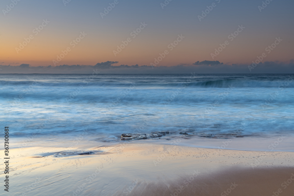 Soft and pretty blue winter sunrise seascape with fog on the horizon