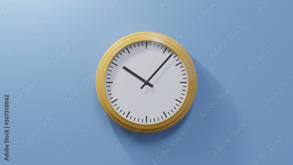 Glossy orange clock on a blue wall at seven past ten. Time is 10:07 or 22:07 Glossy orange clock on a blue wall at seven past ten. Time is 10:07 or 22:07