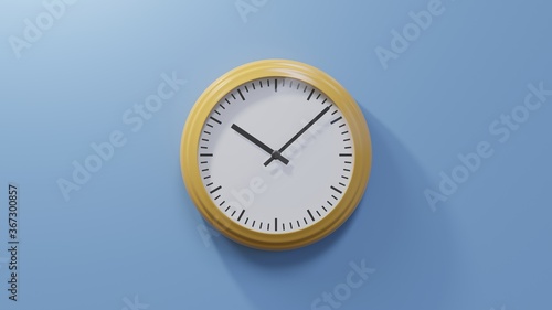 Glossy orange clock on a blue wall at eight past ten. Time is 10:08 or 22:08