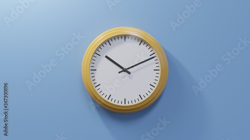 Glossy orange clock on a blue wall at eleven past ten. Time is 10:11 or 22:11