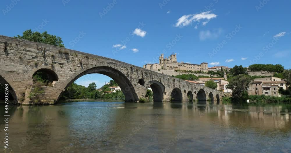 Beziers, Herault, Occitanie, France. In the foreground, the old bridge over crossing the Orb river. In the background is the cathedral Saint Nazaire Beziers, Herault, Occitanie, France. In the foreground, the old bridge over crossing the Orb river. In the background is the cathedral Saint Nazaire