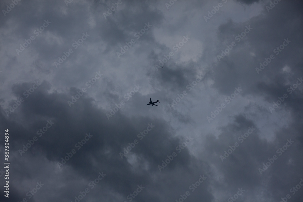 Airplane in the cloudy sky. 