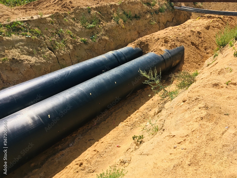 new insulated water pipes in the trench construction site . urban sewerage infrastructure new insulated water pipes in the trench construction site . urban sewerage infrastructure
