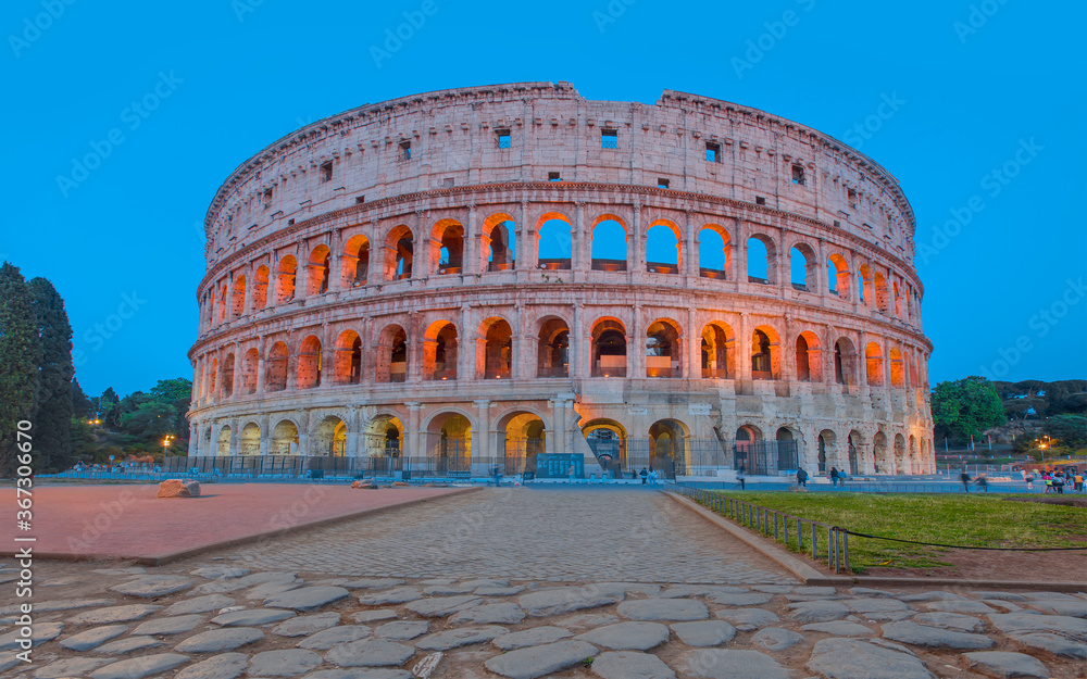 Colosseum amphitheater in Rome at twilight blue hour  with all columns completed - Rome, Italy