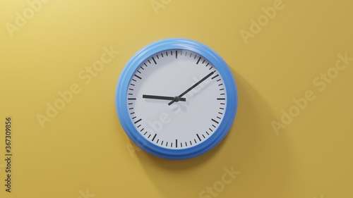 Glossy blue clock on a orange wall at nine past nine. Time is 09:09 or 21:09