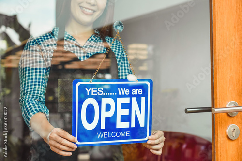 Obraz na płótnie Closeup hand of Asian young woman setting open sign at the shop glasses for welcome the customer in to the coffee shop, small business owner and startup, installing open and close label concept w salonie