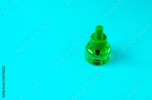 Replacement bottle for a fumigator on a blue background top view. Mosquito protection concept. photo