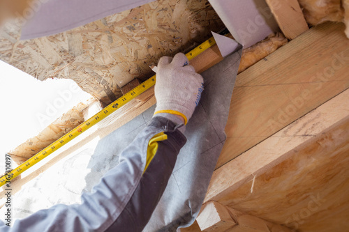 Professional workman using tape, checking plank length