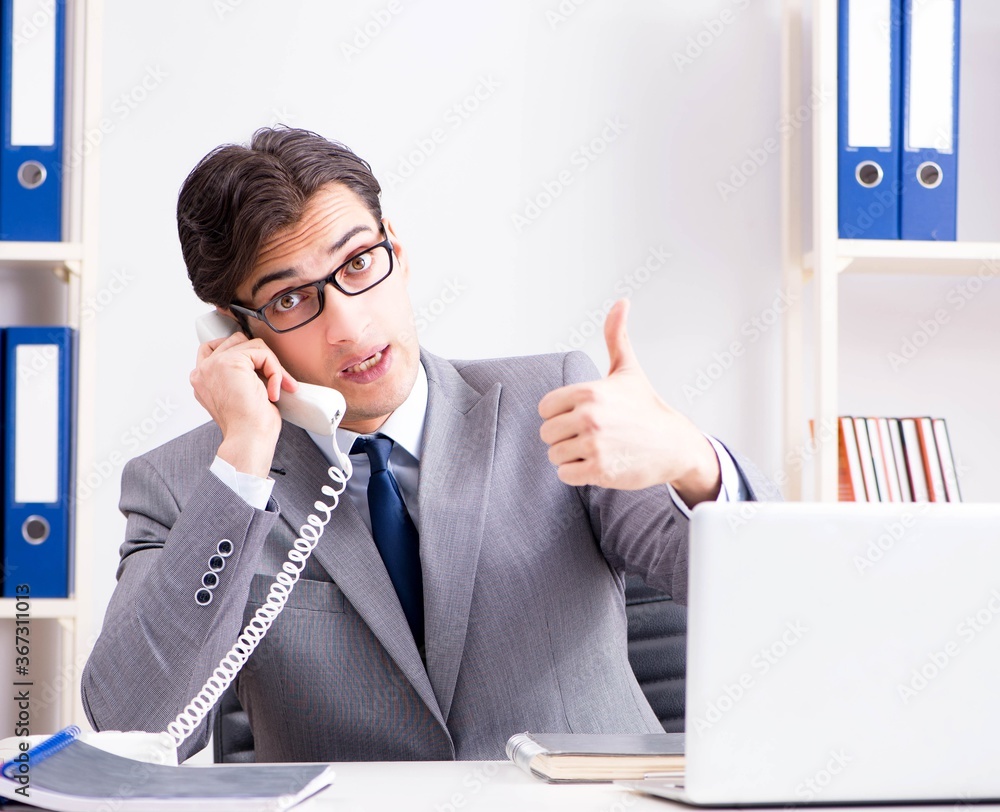 Businessman employee talking on the office phone Businessman employee talking on the office phone