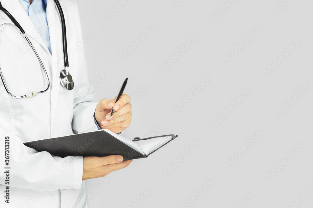 caucasian woman in doctor uniform with stethoscope writing in a notepad, Banner with copy space on blue background. Medicine and healthcare. No face caucasian woman in doctor uniform with stethoscope writing in a notepad, Banner with copy space on blue background. Medicine and healthcare. No face