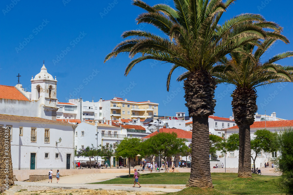 Tourists and locals walking on sunny streets of the Algarve jewel, Lagos town 