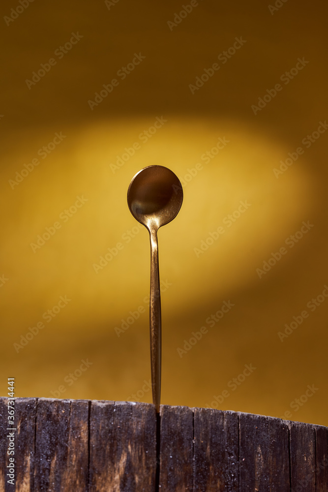 Golden Spoon standing on wooden frame. yellow background Golden Spoon standing on wooden frame. yellow background