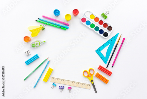 Design template with school stationery and space for text. Background for posting school announcements and advertising extracurricular activities. Multicolored school supplies on a white background