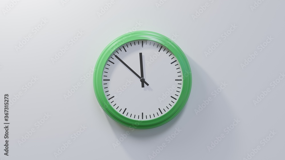 Glossy green clock on a white wall at fifty-two past eleven. Time is 11:52 or 23:52 Glossy green clock on a white wall at fifty-two past eleven. Time is 11:52 or 23:52