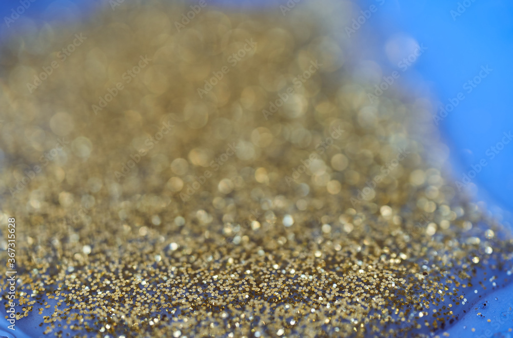 Gold glitter on a dark blue background. blur effect