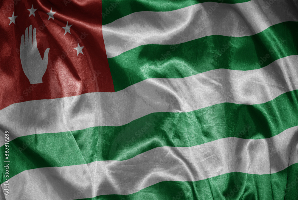 colorful shining big national flag of abkhazia on a silky texture
