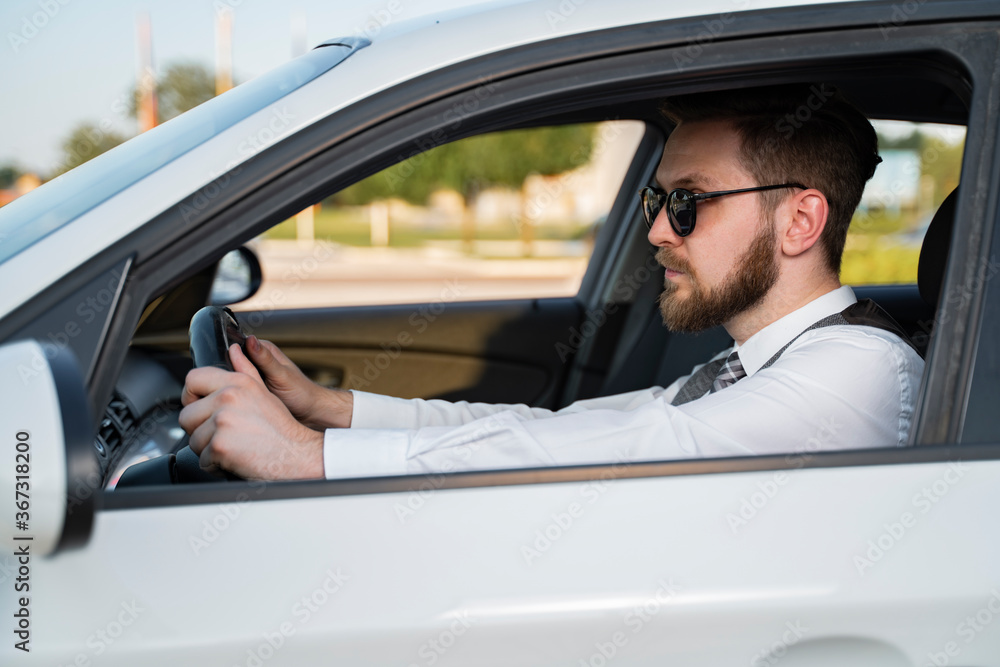 Hipster man with beard behind steering wheel Hipster man with beard behind steering wheel