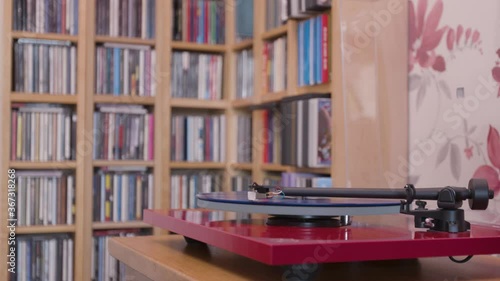 Stopping a blue vinyl lp on a record player and removing stylus mid shot photo