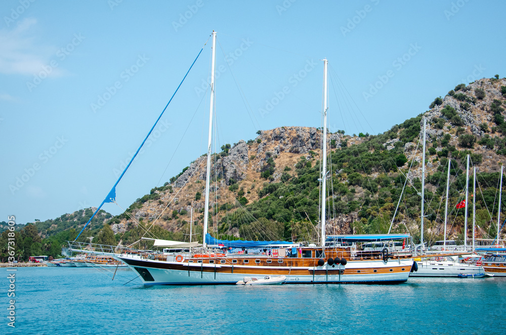 Tourist ship on the background of a beautiful summer mountain landscape on the Mediterranean sea. Excursion to Turkey. Sea tour of the historical monument of architecture. People on vacation