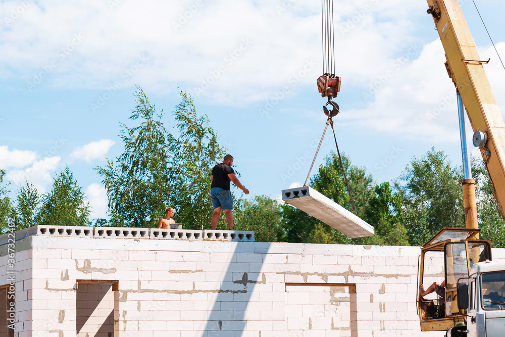 Obraz premium Builder worker installing concrete floor slab panel at building construction site