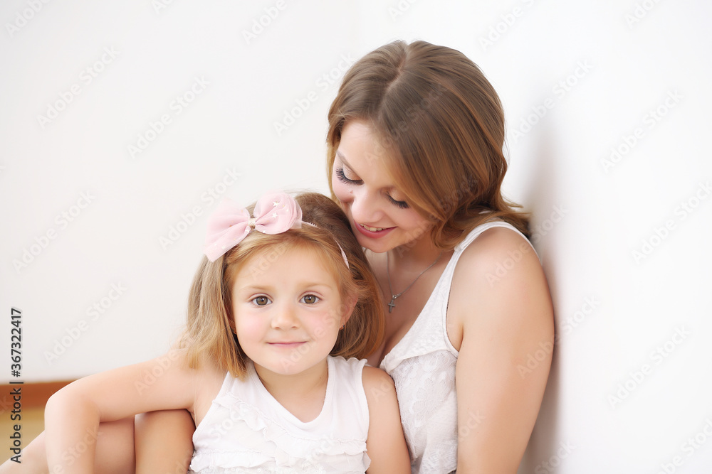 Mother and daughter play hugging lying on the floor in the room Mother and daughter play hugging lying on the floor in the room