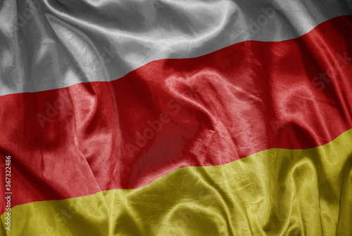 colorful shining big national flag of south ossetia on a silky texture