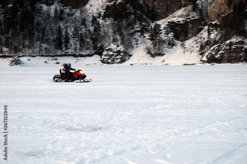 Extreme tourism. Snowmobiling in the mountains. The snow on the rocks. Beautiful winter landscape. Majestic mountain.