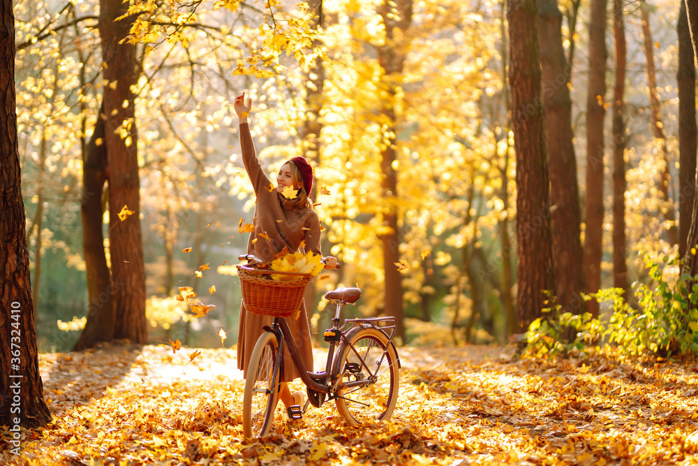 Нappy young woman having fun with leaves in autumn park.  - obrazy, fototapety, plakaty 