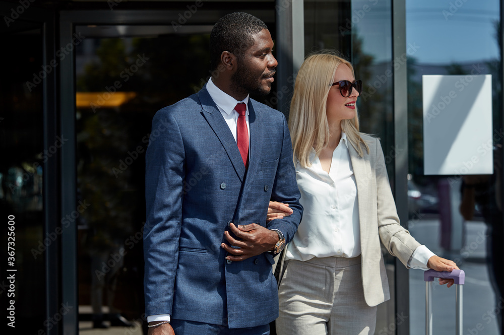beautiful business woman and personal transfer near hotel, confident affable taxi driver or transfer help woman to carry baggage and lead her to the car beautiful business woman and personal transfer near hotel, confident affable taxi driver or transfer help woman to carry baggage and lead her to the car