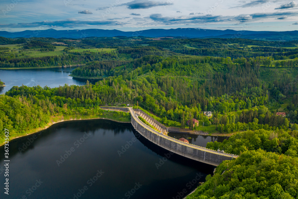 Obraz premium Aerial panoramic view of stone dam at reservoir near Karkonosze mountains. Dam and hydroelectric water power station. Concept of the clean energy. Drone shot at Pilchowice Lake, Poland