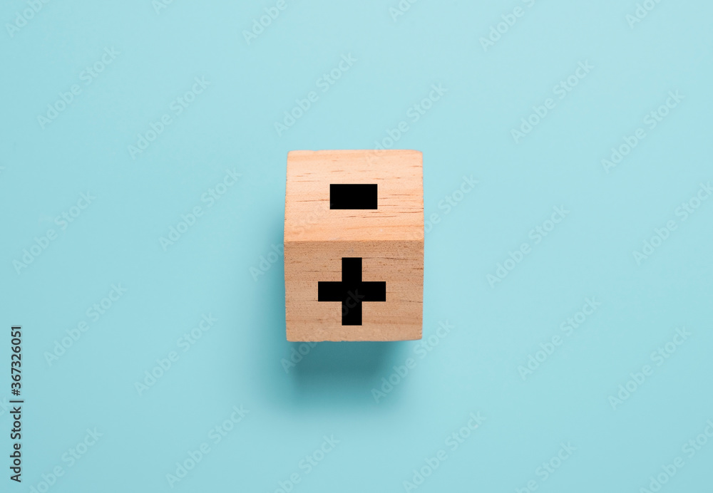 Flipping wooden cube block to change minus sign to plus sign on blue background. Positive thinking and mindset concept. Flipping wooden cube block to change minus sign to plus sign on blue background. Positive thinking and mindset concept.