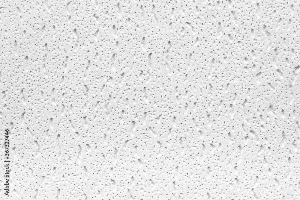 Plaster or cast material. Close up of a white background or texture. Irregular surface with grey and black pores. Plaster or cast material. Close up of a white background or texture. Irregular surface with grey and black pores.