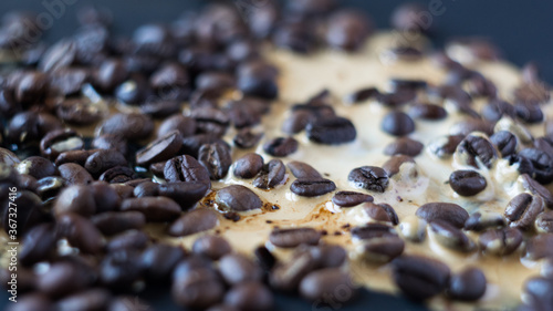 Background coffee beans with spiled coffee, close-up, selective focus photo