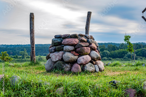 Stone altar in nature on bright sunny day, near water photo