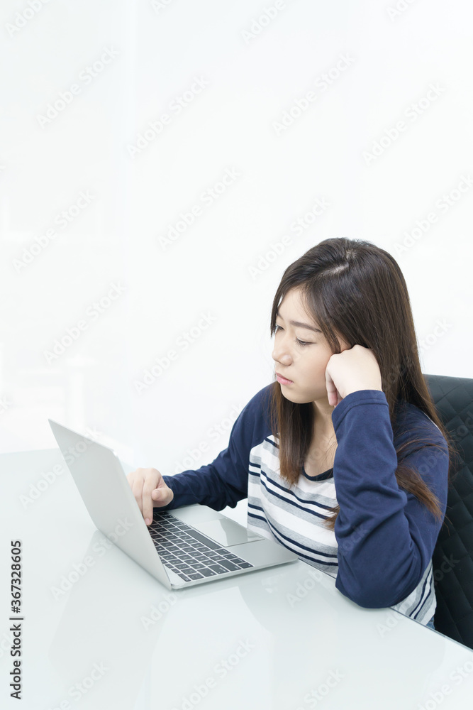 Young female student sitting in living room and learning online Young female student sitting in living room and learning online