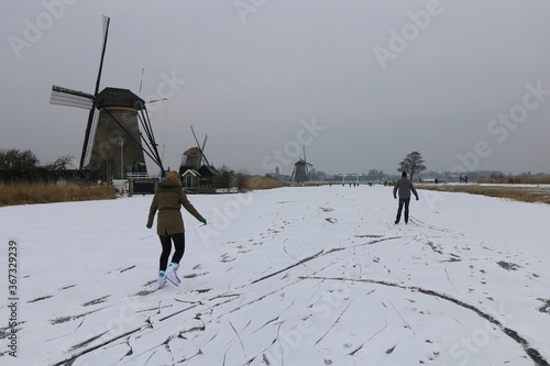 People skate on the frozen canal in kinderdjik, Netherlands. photo