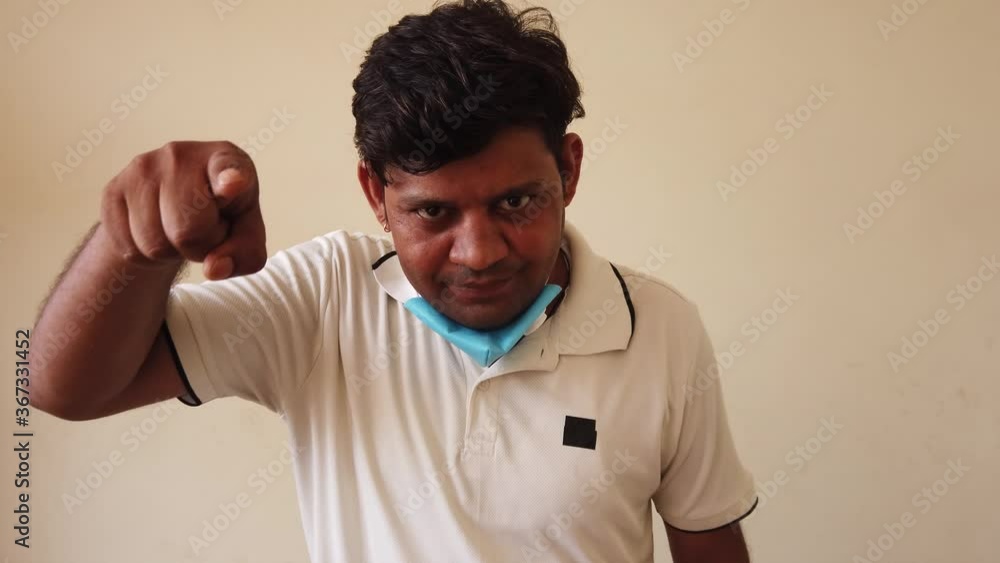medium mid shot portrait of an asian male wearing a face mask for safety precaution against covid19 as he looks at camera and makes various facial expression and hand sign gestures in studio cut-out 