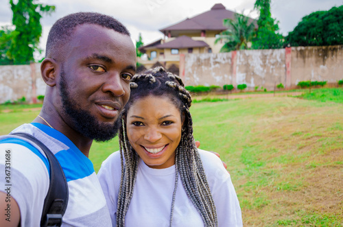 two cute african couples feeling excited as they are taking selfie with their smartphone