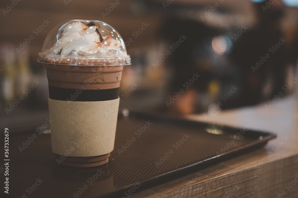 Closeup of takeaway plastic cup of iced cocoa with whipped cream Closeup of takeaway plastic cup of iced cocoa with whipped cream