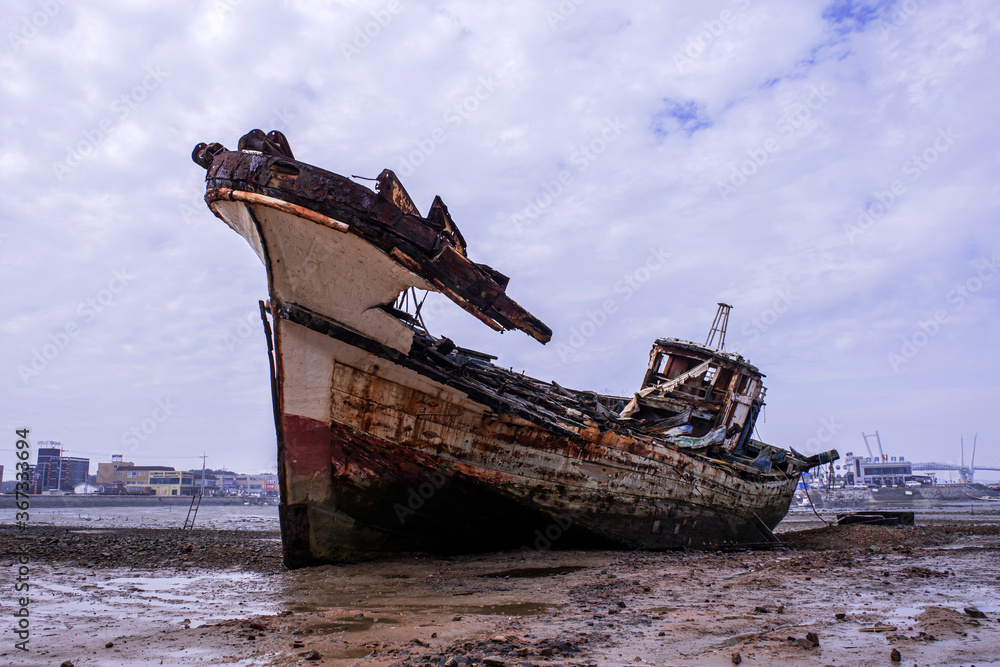 Abandoned and scrapped wooden fishing vessel lying on the beach. Abandoned and scrapped wooden fishing vessel lying on the beach.