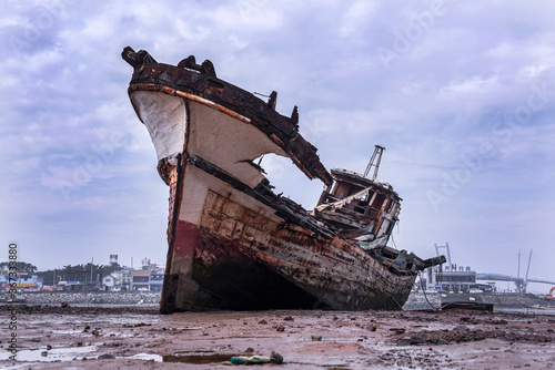  Abandoned and scrapped wooden fishing vessel lying on the beach.